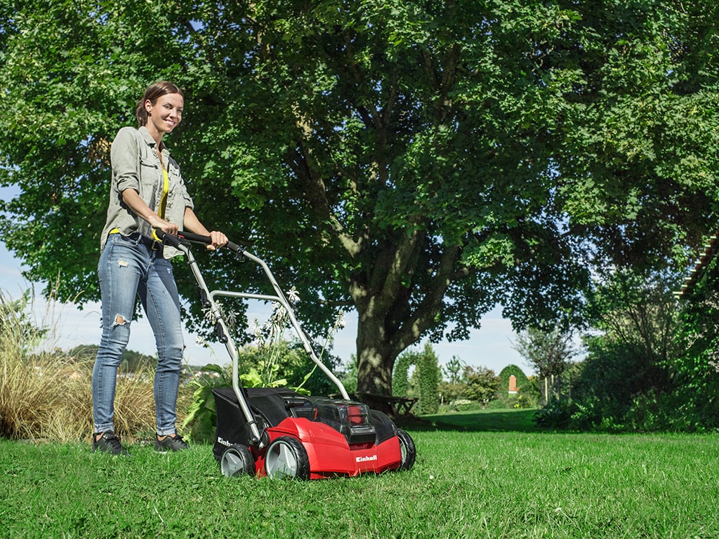 a woman scarifies her lawn