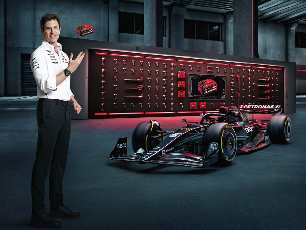 Toto Wolff throws the battery into the air next to a Formula One car